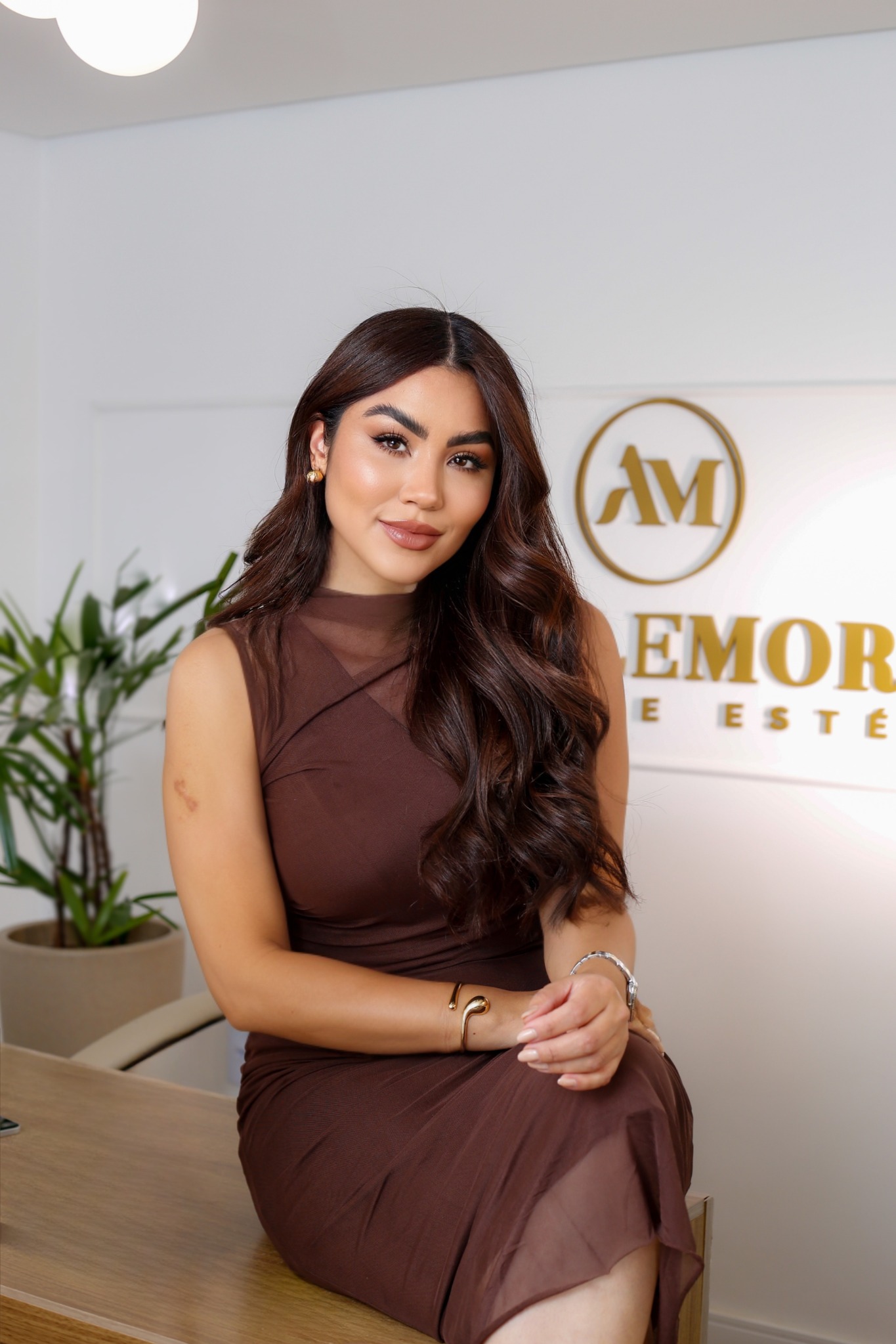Adrielle Moraes na clínica, usando vestido castanho